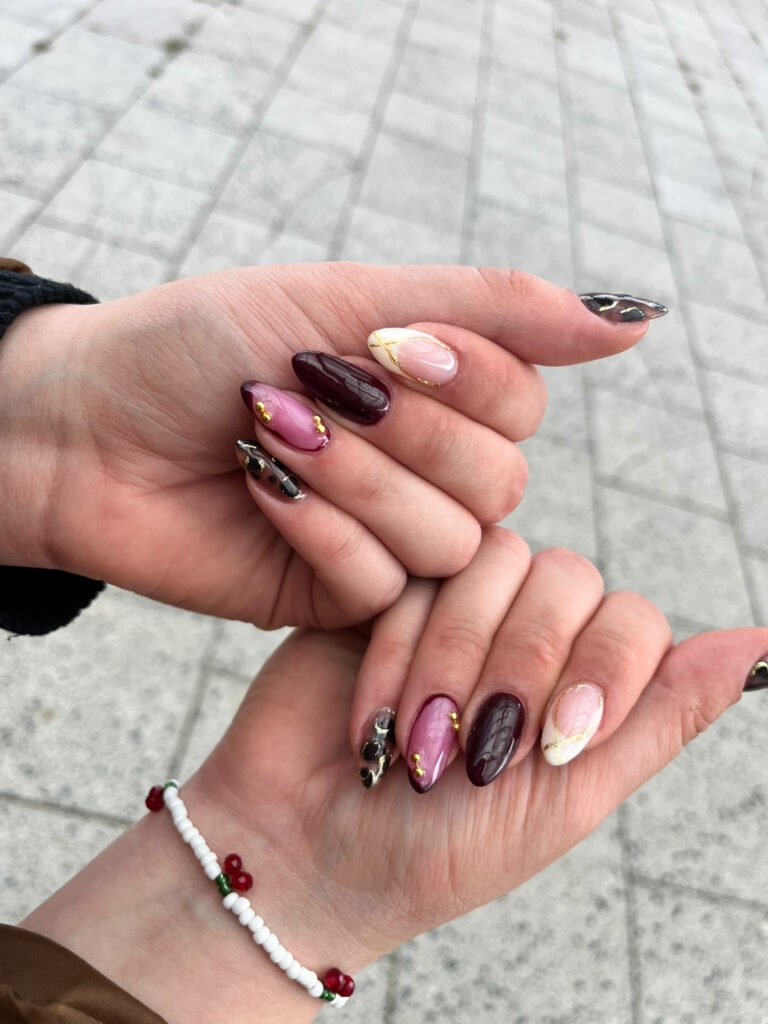 Lange Almond-Nägel im Mix aus Bordeaux, Mauve, Leopard, Goldfolie und zarter Nude-French