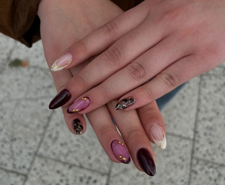 Almond-Nägel in der Nahaufnahme: Bordeaux, Mauve mit Goldflakes, Leopardenmuster und Nude-French mit Goldlinie